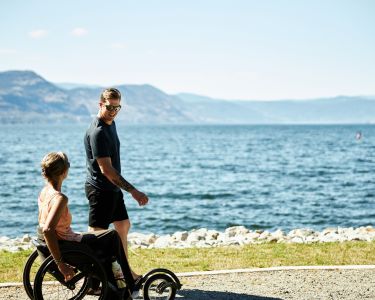 A mother and son taking a stroll and roll along Okanagan Lake
