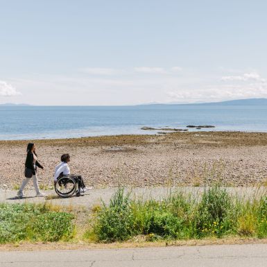 two people enjoying the seaside accessible trail at Point Holmes near Comox