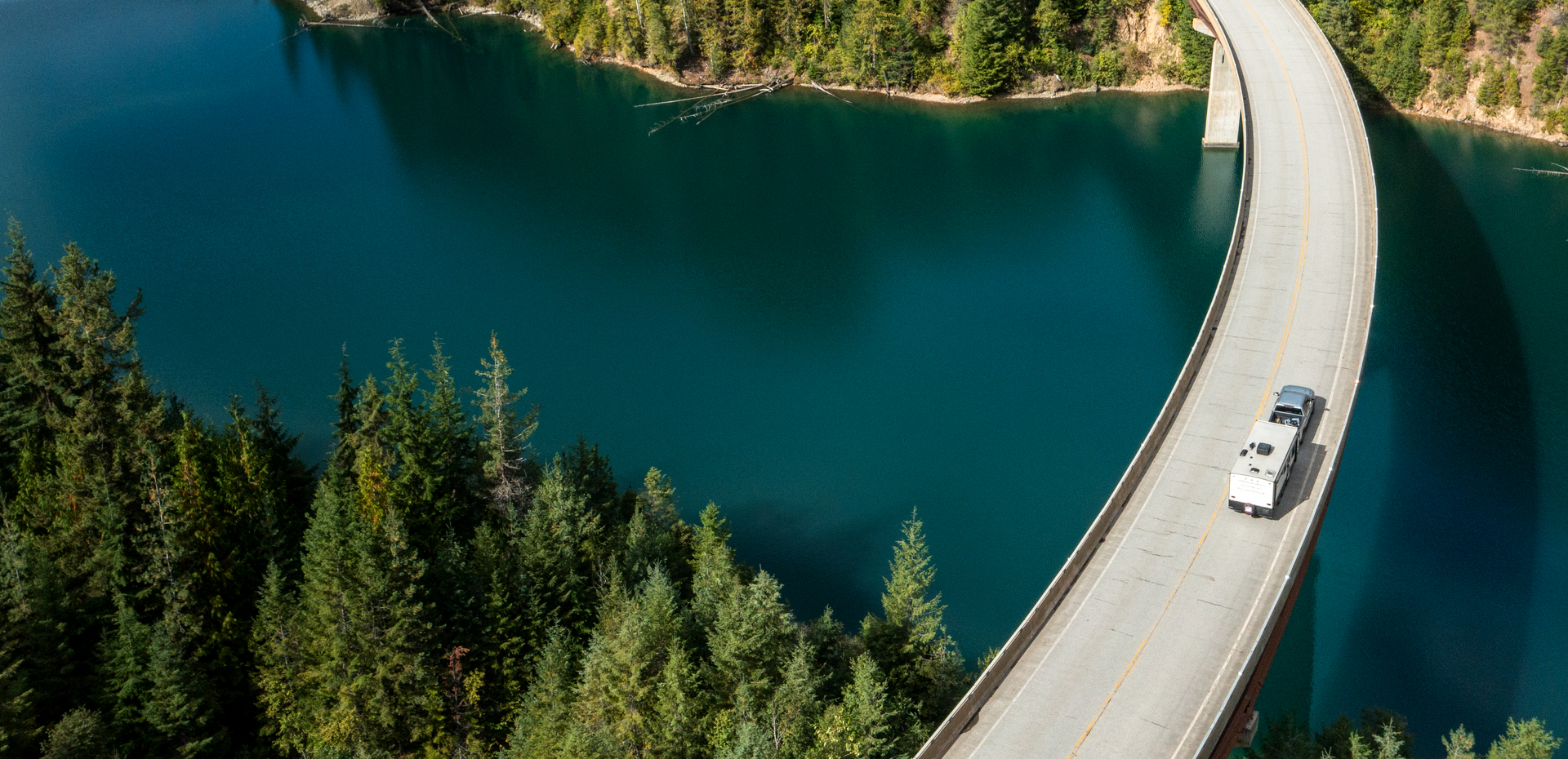 Aerial view of an RV crossing a bridge over a lake.