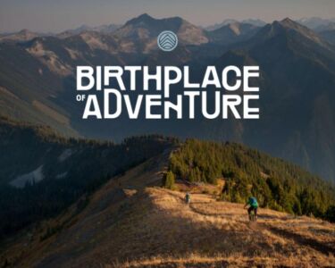 People biking up a treed landscape in the mountains, with a logo overlaid.